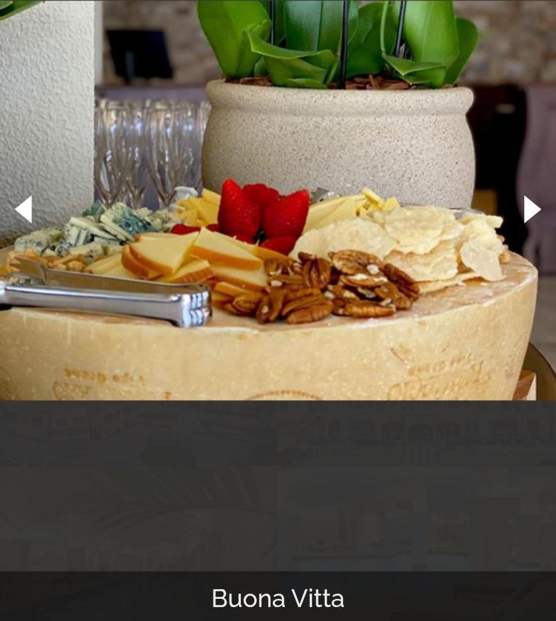 Buona Vitta Gramado Resort & Spa By Gramado Parks Kültér fotó The photo displays a beautiful cheese platter. It features a large round cheese wheel as the base, surrounded by various types of cheeses including soft and hard varieties. There are also some crackers or crisps, along with nuts, particularly pecans.
