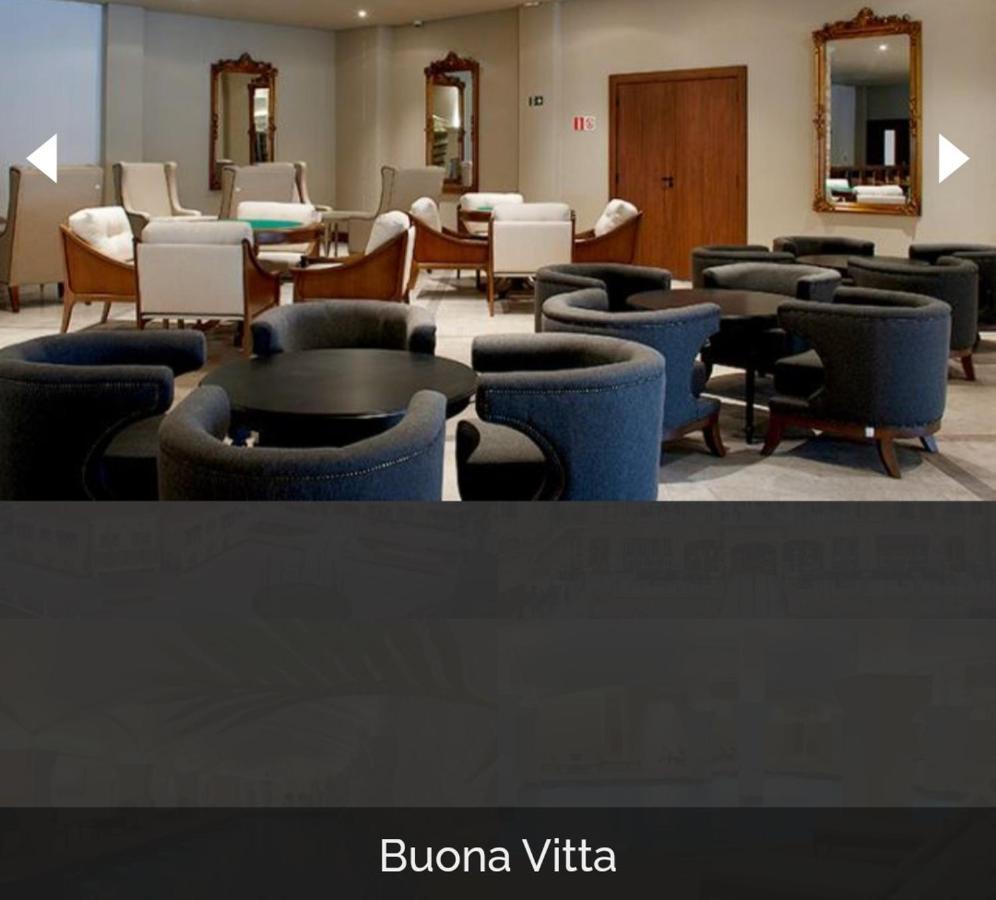 Buona Vitta Gramado Resort & Spa By Gramado Parks Kültér fotó The photo shows a modern, elegantly designed lounge or waiting area. It features several circular seating arrangements with dark blue armchairs surrounding black tables. In the background, there are light-colored lounge chairs and a wooden door leadi