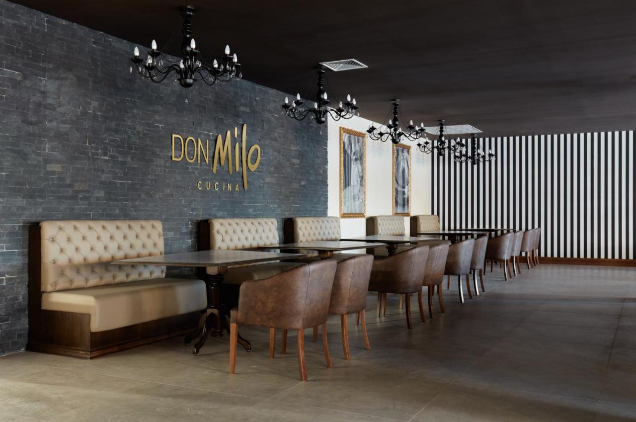 Buona Vitta Gramado Resort & Spa By Gramado Parks Kültér fotó The photo showcases an interior of a restaurant named "Don Milo." The design features a modern and sophisticated look with a mix of textures and colors. 

On one side, there are upholstered booths in a neutral tone, creating a comfortable dining area