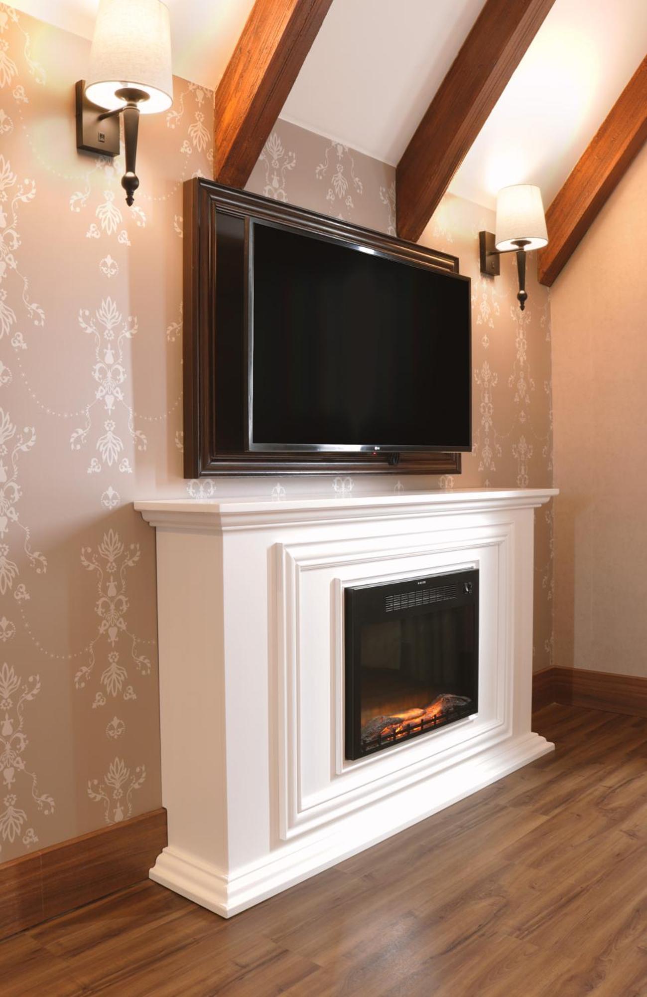 Buona Vitta Gramado Resort & Spa By Gramado Parks Kültér fotó The image shows a modern living room setup featuring a white mantel with an electric fireplace. Above the mantel, there is a large flat-screen television mounted on the wall. The fireplace has a glass front and displays a realistic flame effect, crea